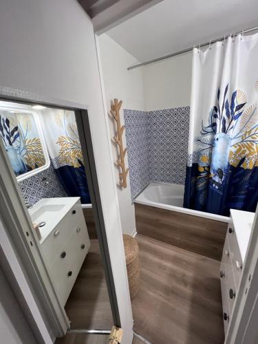 La salle de bains est pourvue d'une baignoire et d'un rideau de douche. dans l'établissement L'air de la mer deux étoiles, à Dieppe