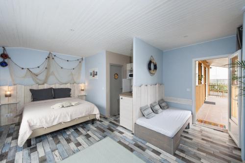um quarto com paredes azuis, uma cama e uma varanda em Le Studio de Noreda em Gujan-Mestras