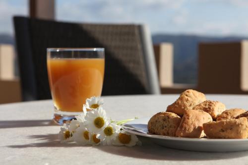 a plate of food with a glass of orange juice and flowers at Aori Hillside Villa in Kántanos