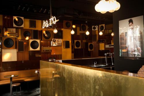 a restaurant with a bar with a counter and records on the wall at HotelO Kathedral in Antwerp