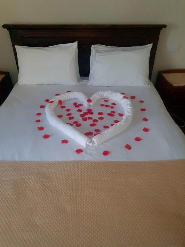 a heart made out of red hearts on a bed at Rose Tor Hotel in Llandudno