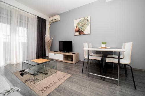 a living room with a table and a television at Ring Inn Apartments in Obrenovac