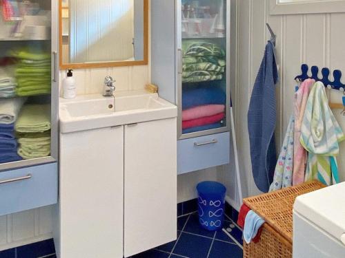 ein Badezimmer mit einem Waschbecken, einem Spiegel und Handtüchern in der Unterkunft Holiday home Åsenfjord 