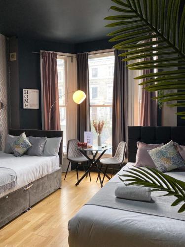 倫敦的住宿－Holland Road Stays，一间卧室配有两张床和一张桌椅