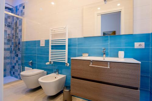 a bathroom with a toilet and a sink and a mirror at Leone Suites Toledo in Naples