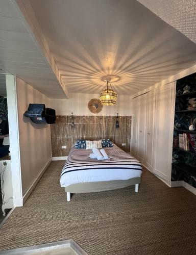 une chambre avec un grand lit avec un plafond dans l'établissement L'air de la mer deux étoiles, à Dieppe
