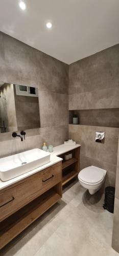 La salle de bains est pourvue d'un lavabo et de toilettes. dans l'établissement sea side eilat holiday apartment, à Eilat