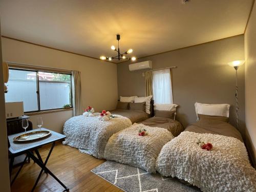 three beds in a room with a table at Best Shinjuku Modern Full-furnished Apartment2 ONLY 2min to Shinjuku by Train in Tokyo