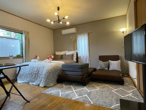 a bedroom with a bed and a table and a tv at Best Shinjuku Modern Full-furnished Apartment2 ONLY 2min to Shinjuku by Train in Tokyo