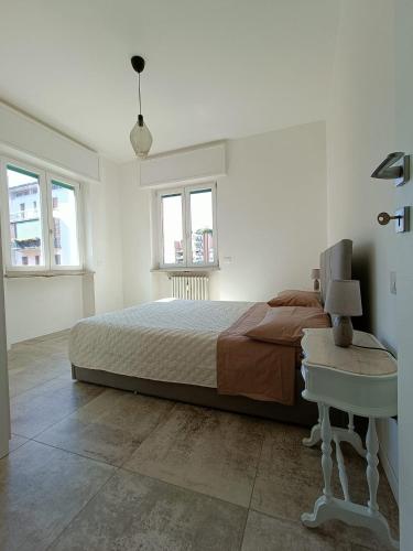 Schlafzimmer mit einem Bett, einem Tisch und Fenstern in der Unterkunft 'Na Chicca A Verona in Verona