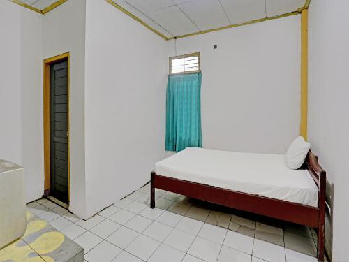a small bed in a room with a window at SPOT ON 92446 Penginapan Aina Syariah 