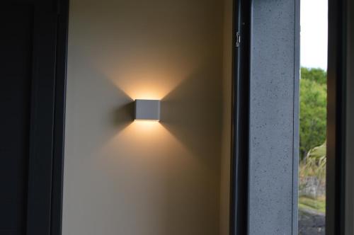 a light on a wall next to a window at B&B Dimora dell' Etna in Milo