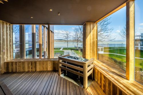 a large room with windows and a stove on a deck at Mövenpick Balaland Resort Lake Balaton in Szántód