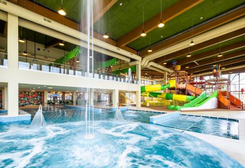 a large indoor swimming pool with a water slide at Mövenpick Balaland Resort Lake Balaton in Szántód