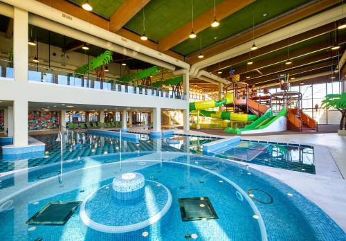 a large indoor swimming pool in a building at Mövenpick Balaland Resort Lake Balaton in Szántód