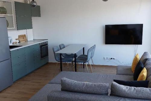 a living room with a couch and a table and a kitchen at Fiume Panorama Residence with free garage in Budapest