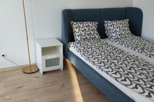 een slaapkamer met een blauw bed en een bijzettafel bij Fiume Panorama Residence with free garage in Boedapest
