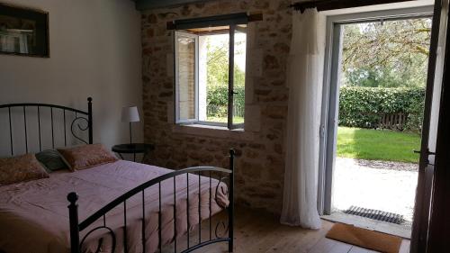a bedroom with a bed and a large window at Le Marais in Chasseneuil-sur-Bonnieure