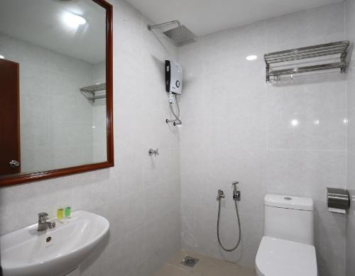 W łazience znajduje się umywalka, toaleta i lustro. w obiekcie LA ISRA at KL w Kuala Lumpur