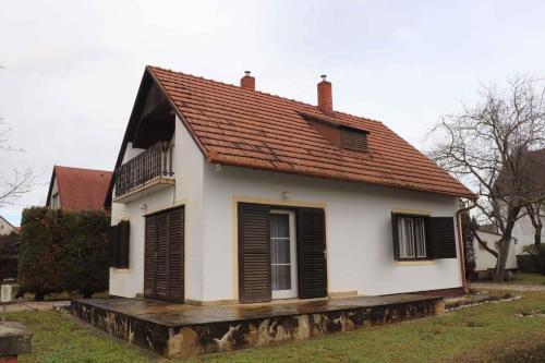 a small white house with a red roof at Holiday home Vonyarcvashegy - Balaton 20304 in Vonyarcvashegy