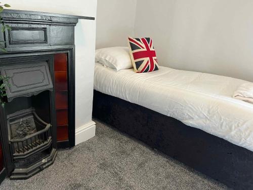 a bedroom with a bed and a fireplace at The North Wales Gathering - Hot Tub & Sleeps Up To 16 in St Asaph