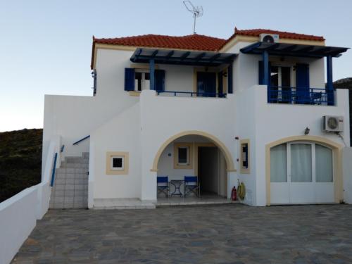 a white house with blue doors and a patio at Απεραντο Γαλαζιο in Agia Pelagia Kythira
