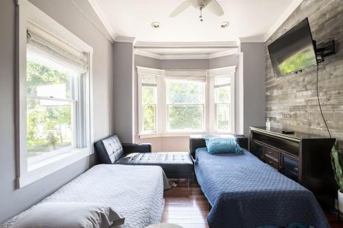 Zimmer mit 2 Betten, einem TV und 2 Fenstern in der Unterkunft Riverfront Penthouse Suite in Midtown Harrisburg near Hershey in Harrisburg