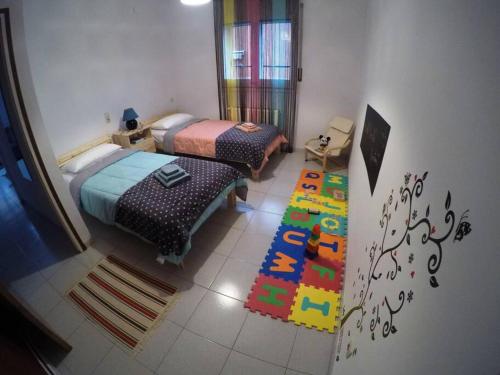 a bedroom with two beds and a rug on the floor at Cool Breeze Apartment in Maçanet de Cabrenys