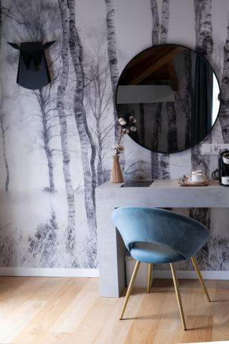 a room with a mirror and a blue chair at Hotel Sol Boutique in Santander