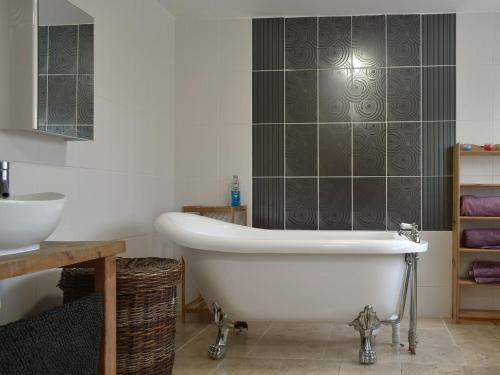 a bathroom with a white bath tub and a sink at Middle Farm in East Harling