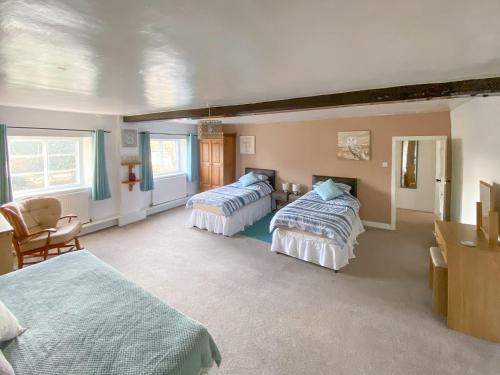 East HarlingにあるMiddle Farmのベッドルーム1室(ベッド2台、テーブル、椅子付)