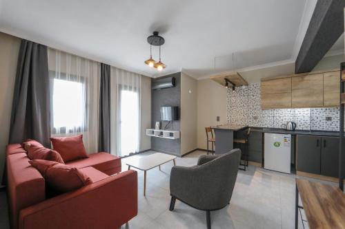 een woonkamer met een rode bank en een keuken bij İNCİ BOUTİQUE APART in Bodrum City