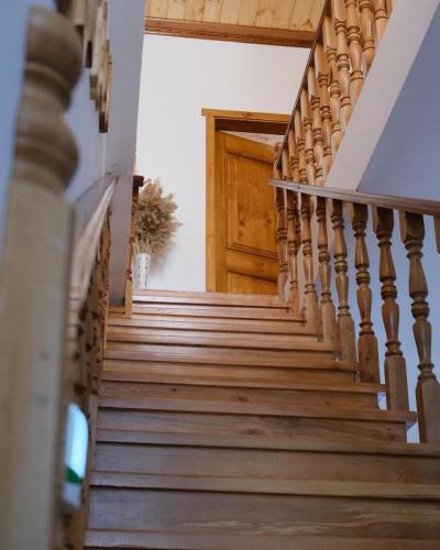 a staircase in a house with a wooden door at As e vogël, As e madhe in Ersekë