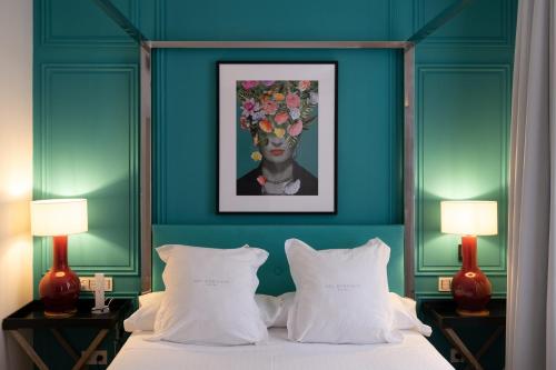 a bedroom with a bed with a painting of a woman at Hotel Sol Boutique in Santander