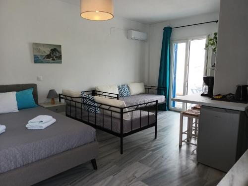 ein Wohnzimmer mit einem Bett und einem Sofa in der Unterkunft Athina's blue studios in Naoussa
