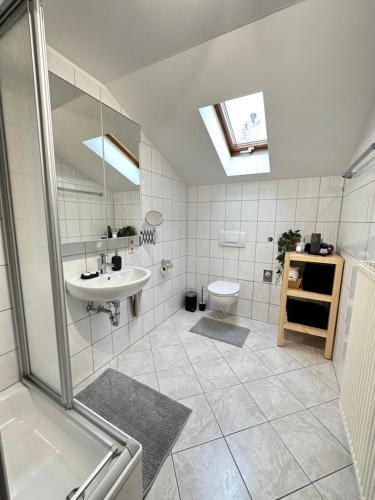a white bathroom with a sink and a toilet at Ferienwohnung Haus Reindl in Walchensee