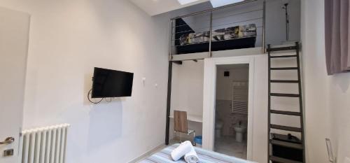 Residence Jolly في ميلانو: غرفة مع سرير بطابقين مع سلم وتلفزيون