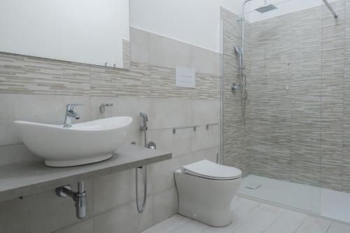 a bathroom with a sink and a toilet and a shower at VeMi Affittacamere in Posada