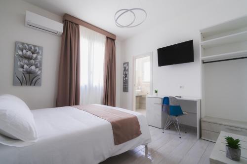 a bedroom with a bed and a desk and a television at VeMi Affittacamere in Posada