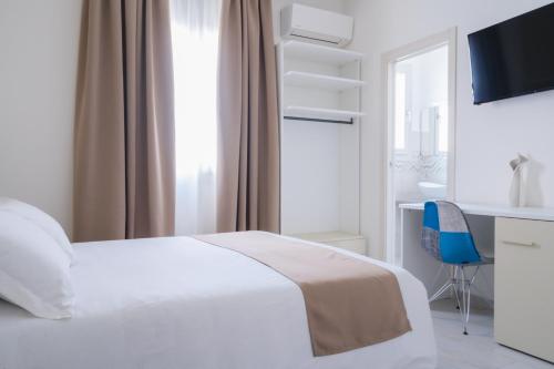 a bedroom with a white bed and a blue chair at VeMi Affittacamere in Posada