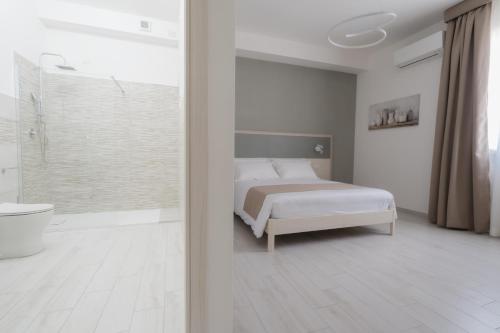 1 dormitorio con cama, bañera y ducha en VeMi Affittacamere, en Posada