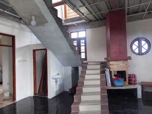 a room with a staircase and a clock on the wall at Kopa HillTop Family GuestHome in Ruteng