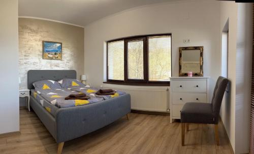 a bedroom with a bed and a chair and a mirror at Vila Marina Ilkoni at Jrebchevo dam in Kriva Krusha