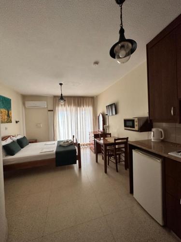 アヤナパにあるEstia Vasilis Manoliのベッド1台付きの部屋、テーブル付きのキッチンが備わる客室です。