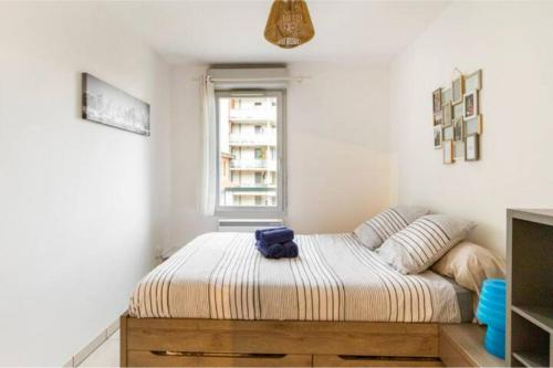 Un dormitorio con una cama con una toalla azul. en Appartement T2 40 m2 - Tout équipé et calme, en Toulouse