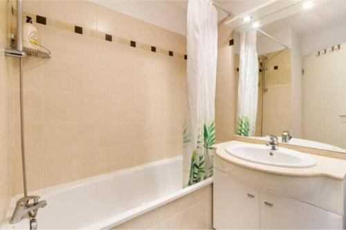 een badkamer met een wastafel, een bad en een wastafel bij Appartement T2 40 m2 - Tout équipé et calme in Toulouse