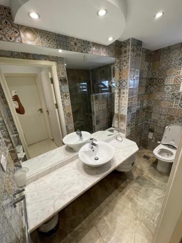 a bathroom with two sinks and a toilet at Delta Sharm Apartments with free Internet Wi-Fi in Sharm El Sheikh