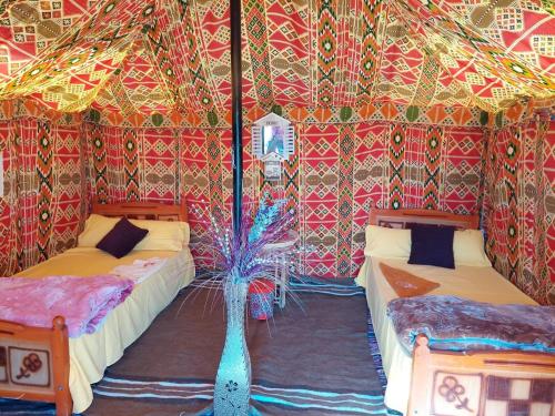 a room with two beds in a tent at stars camp oasis in Bawiti
