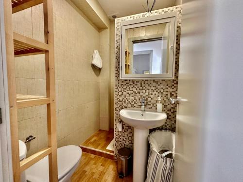 a bathroom with a sink and a toilet and a mirror at Casita de Bolonia in Bolonia