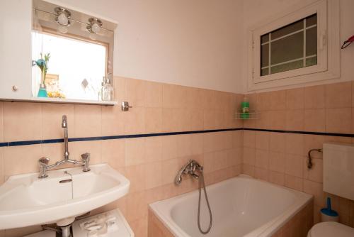 a bathroom with a sink and a bath tub at marina's home in village in Kornáta